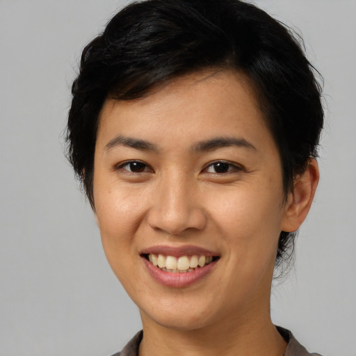 Joyful asian young-adult female with short  brown hair and brown eyes