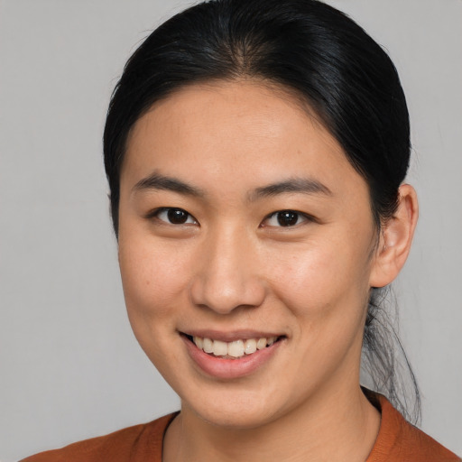Joyful asian young-adult female with medium  brown hair and brown eyes