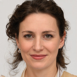 Joyful white young-adult female with medium  brown hair and green eyes