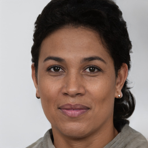 Joyful latino adult female with short  brown hair and brown eyes