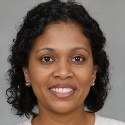 Joyful black young-adult female with medium  brown hair and brown eyes
