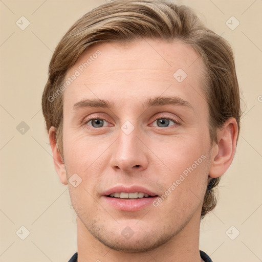 Joyful white young-adult male with short  brown hair and grey eyes