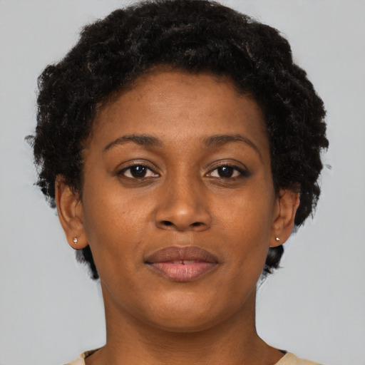 Joyful black young-adult female with short  brown hair and brown eyes