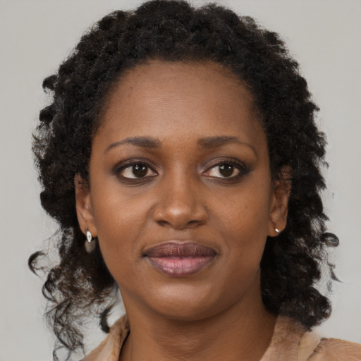 Joyful black young-adult female with medium  brown hair and brown eyes