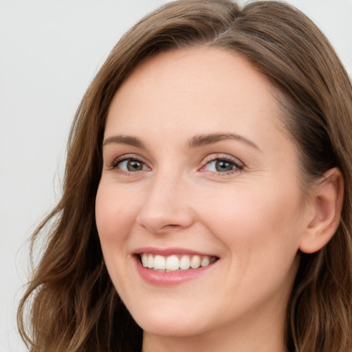 Joyful white young-adult female with long  brown hair and blue eyes