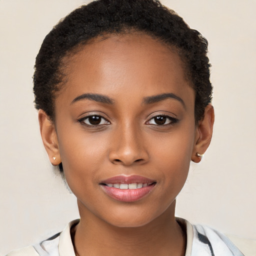 Joyful black young-adult female with short  black hair and brown eyes