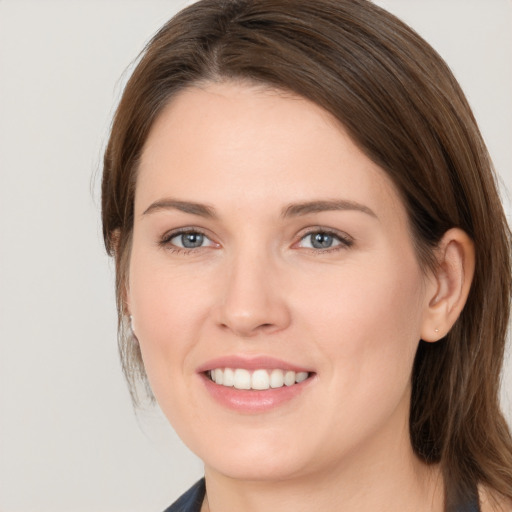 Joyful white young-adult female with medium  brown hair and grey eyes