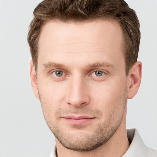 Joyful white young-adult male with short  brown hair and grey eyes