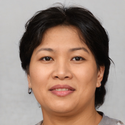 Joyful asian adult female with medium  brown hair and brown eyes