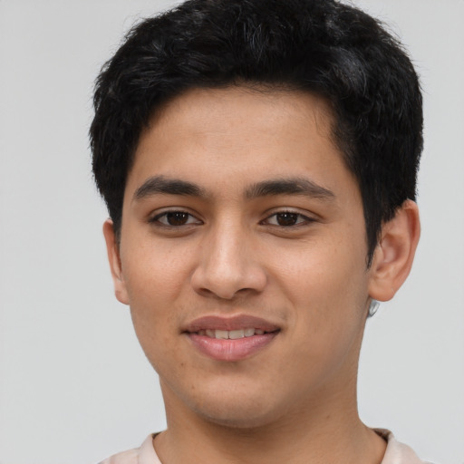 Joyful latino young-adult male with short  brown hair and brown eyes