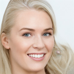 Joyful white young-adult female with long  brown hair and blue eyes