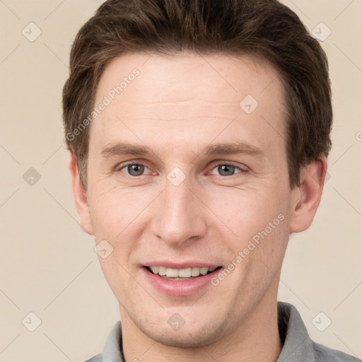 Joyful white young-adult male with short  brown hair and grey eyes