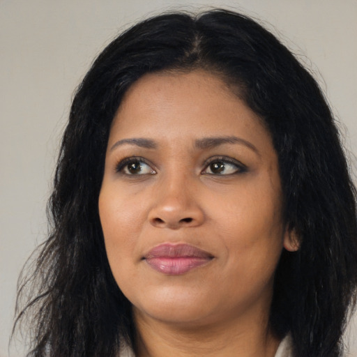 Joyful black young-adult female with long  black hair and brown eyes