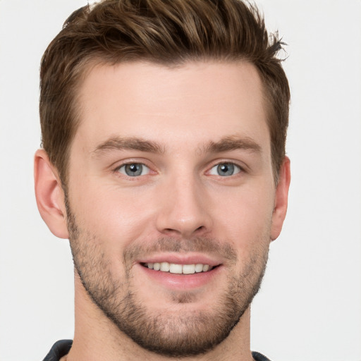 Joyful white young-adult male with short  brown hair and grey eyes