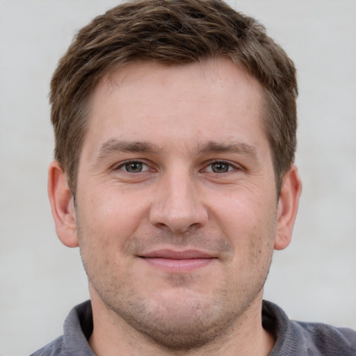 Joyful white adult male with short  brown hair and grey eyes