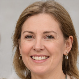 Joyful white adult female with long  brown hair and grey eyes