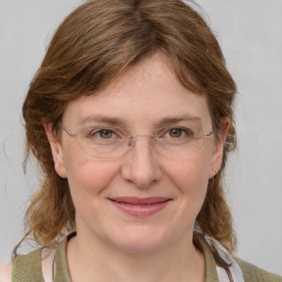 Joyful white adult female with medium  brown hair and blue eyes