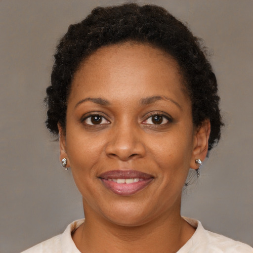 Joyful black adult female with short  brown hair and brown eyes