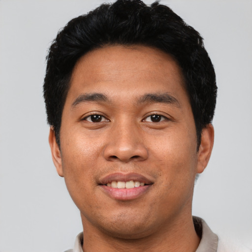 Joyful latino young-adult male with short  black hair and brown eyes