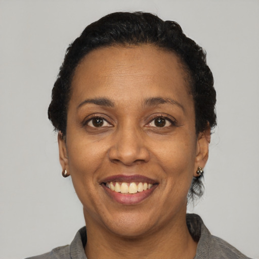 Joyful black adult female with short  black hair and brown eyes