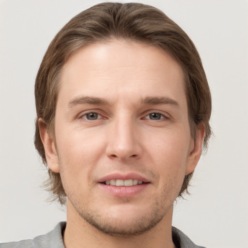 Joyful white young-adult male with short  brown hair and grey eyes