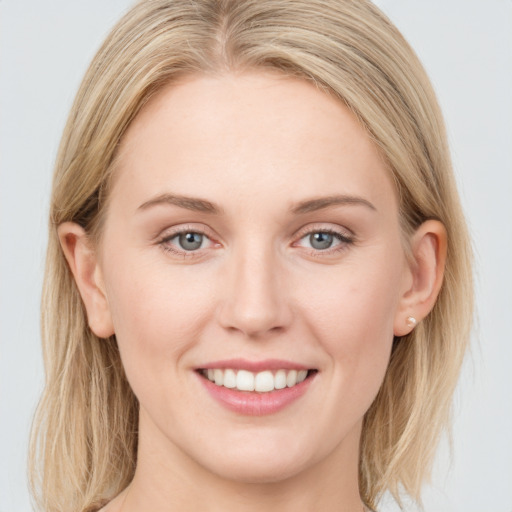 Joyful white young-adult female with long  brown hair and blue eyes