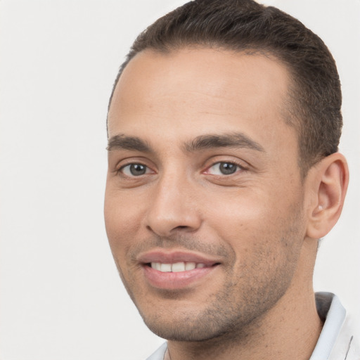 Joyful white young-adult male with short  brown hair and brown eyes