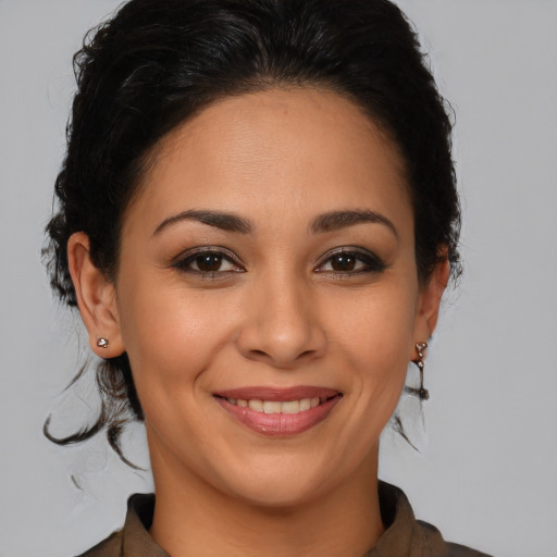 Joyful latino young-adult female with medium  brown hair and brown eyes