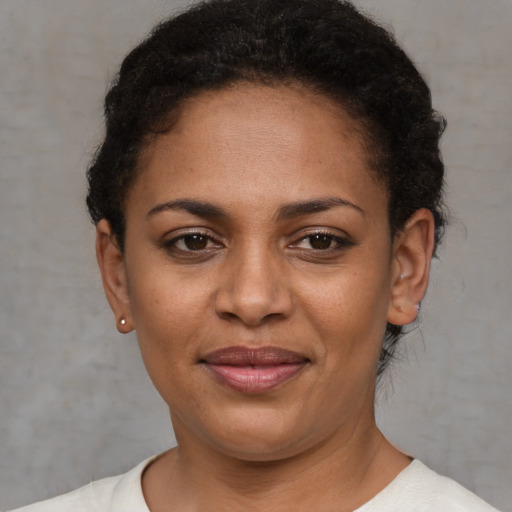 Joyful black young-adult female with short  brown hair and brown eyes