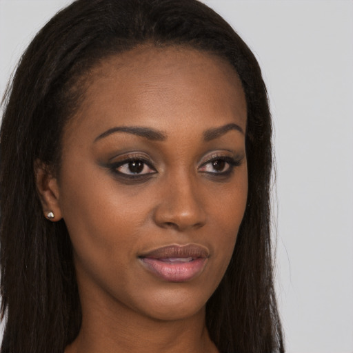 Joyful black young-adult female with long  brown hair and brown eyes
