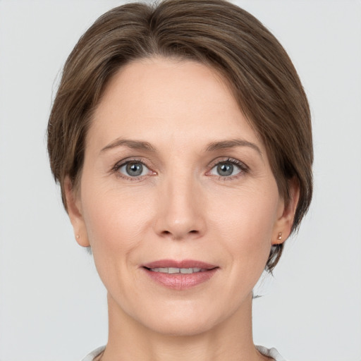 Joyful white adult female with medium  brown hair and grey eyes