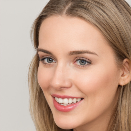 Joyful white young-adult female with long  brown hair and grey eyes