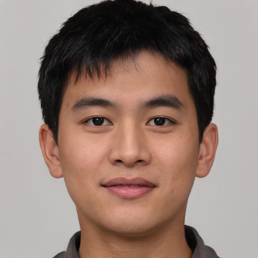 Joyful asian young-adult male with short  black hair and brown eyes