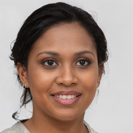 Joyful black young-adult female with medium  brown hair and brown eyes
