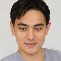 Joyful asian young-adult male with short  black hair and brown eyes