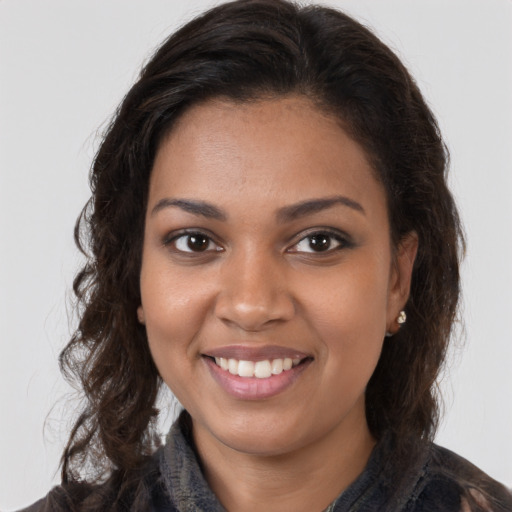 Joyful black young-adult female with long  brown hair and brown eyes