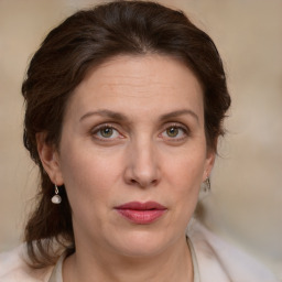 Joyful white adult female with medium  brown hair and green eyes