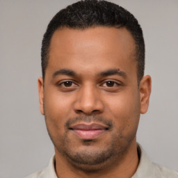 Joyful latino young-adult male with short  black hair and brown eyes