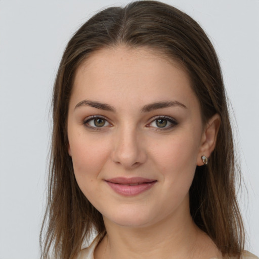 Joyful white young-adult female with long  brown hair and green eyes