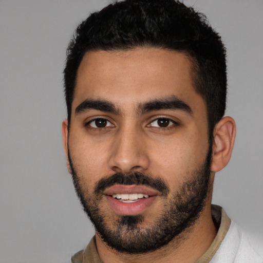 Joyful latino young-adult male with short  black hair and brown eyes