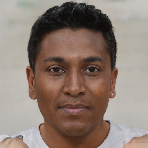 Joyful latino young-adult male with short  black hair and brown eyes