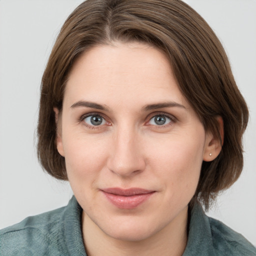 Joyful white young-adult female with medium  brown hair and grey eyes