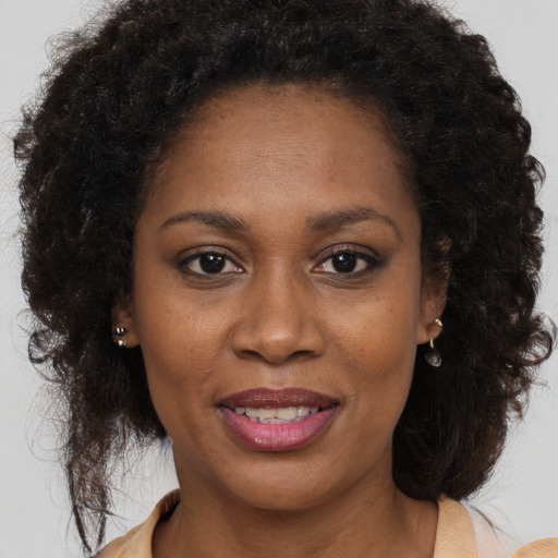 Joyful black adult female with long  brown hair and brown eyes