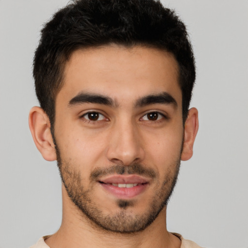 Joyful latino young-adult male with short  brown hair and brown eyes