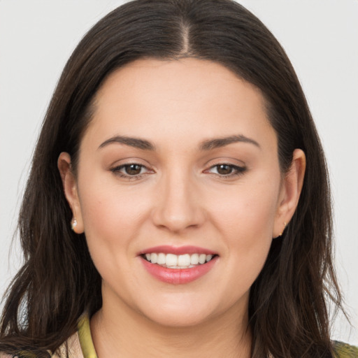 Joyful white young-adult female with long  brown hair and brown eyes