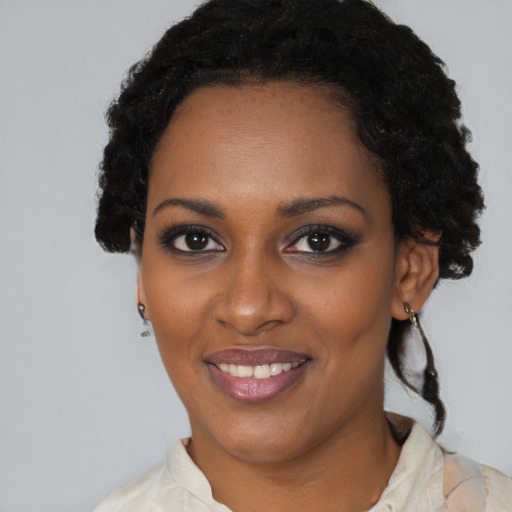 Joyful black young-adult female with short  black hair and brown eyes