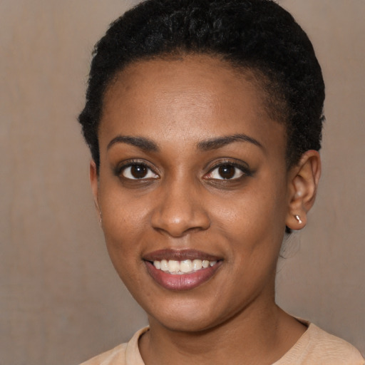 Joyful black young-adult female with short  brown hair and brown eyes