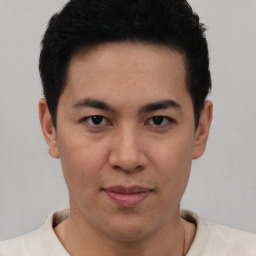Joyful latino young-adult male with short  brown hair and brown eyes