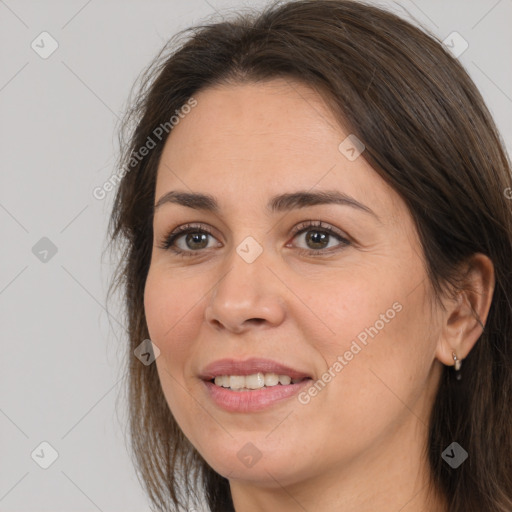 Joyful white adult female with long  brown hair and brown eyes