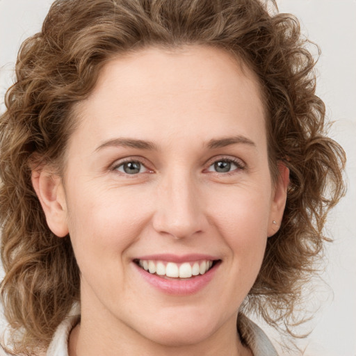 Joyful white young-adult female with medium  brown hair and green eyes